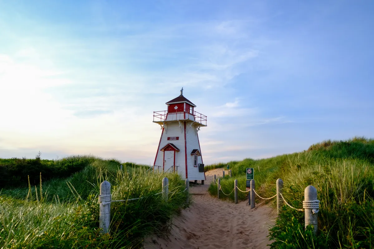 Leuchtturm vor blauem Himmel und grünem Gras auf PEI
