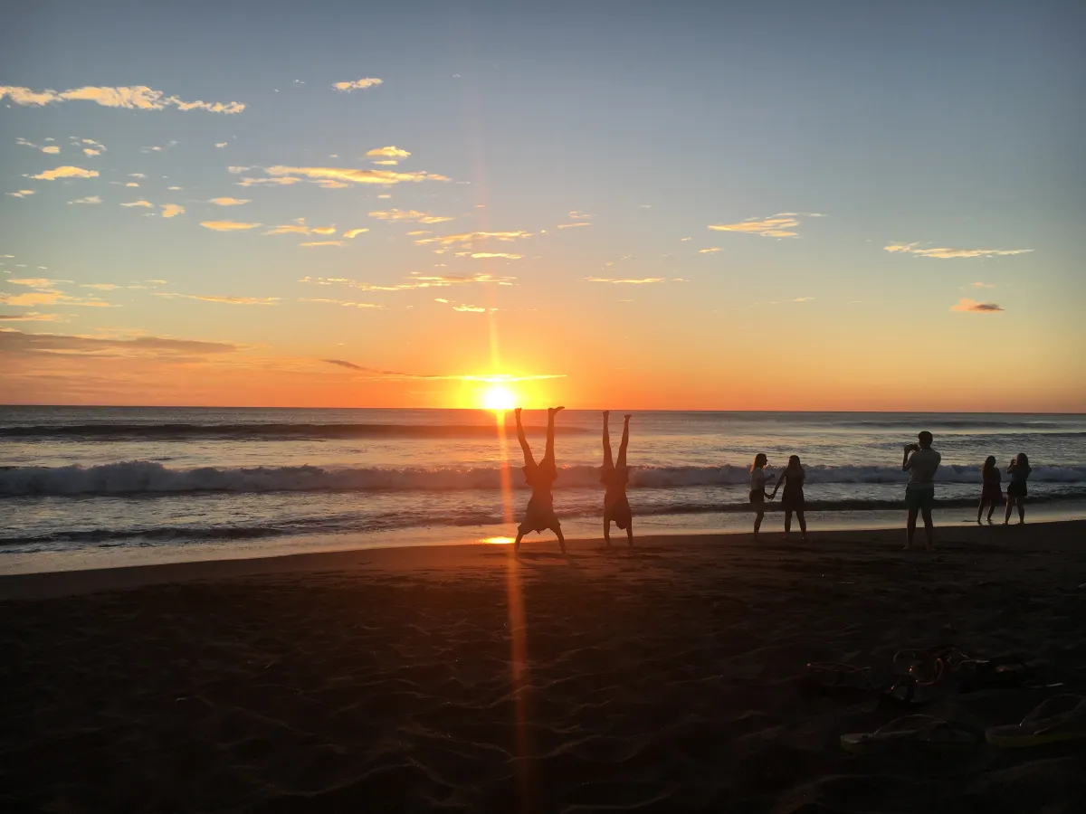 Sonnenuntergang am Strand Teenager machen Handstände