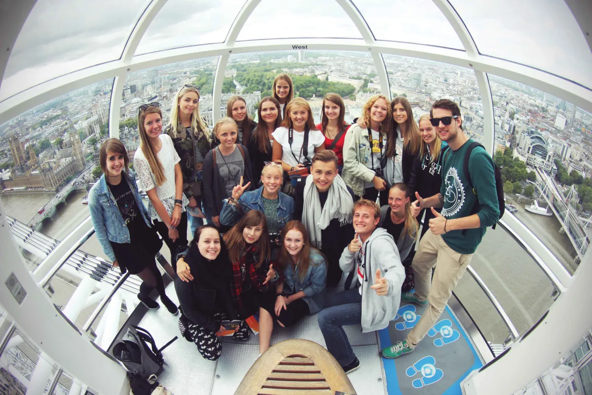 Gruppe von Austauschschüler mit Selfiestick in Hochhaus in London
