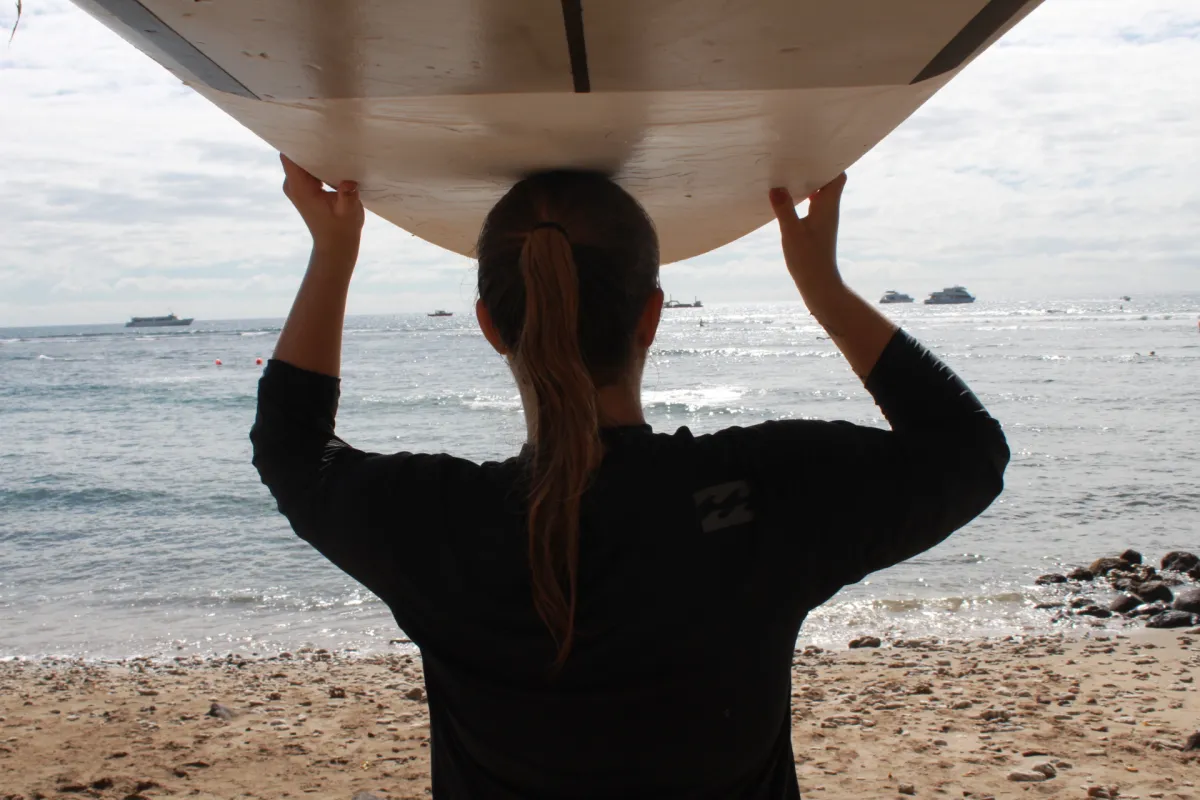 Surfer mit Board auf Kopf