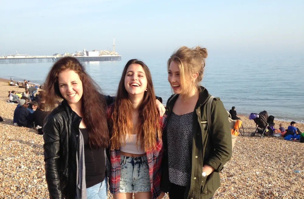 Drei Mädchen lachen am Strand in Südengland