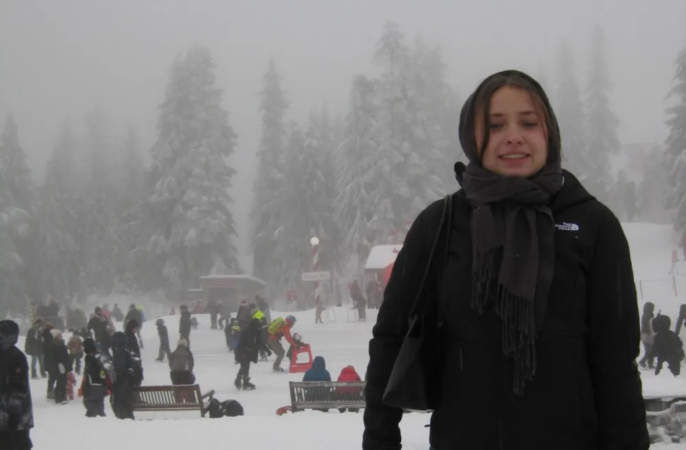 Austauschschülerin bei Schnee und Nebel vor einer Eisbahn