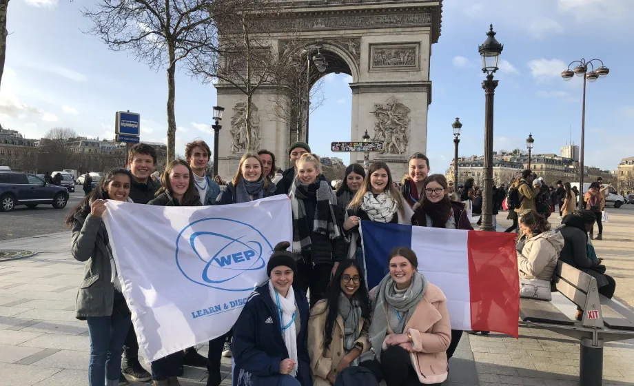 Gruppenbild von Austauschschüler mit französischer Flagge vor dem Eiffelturm