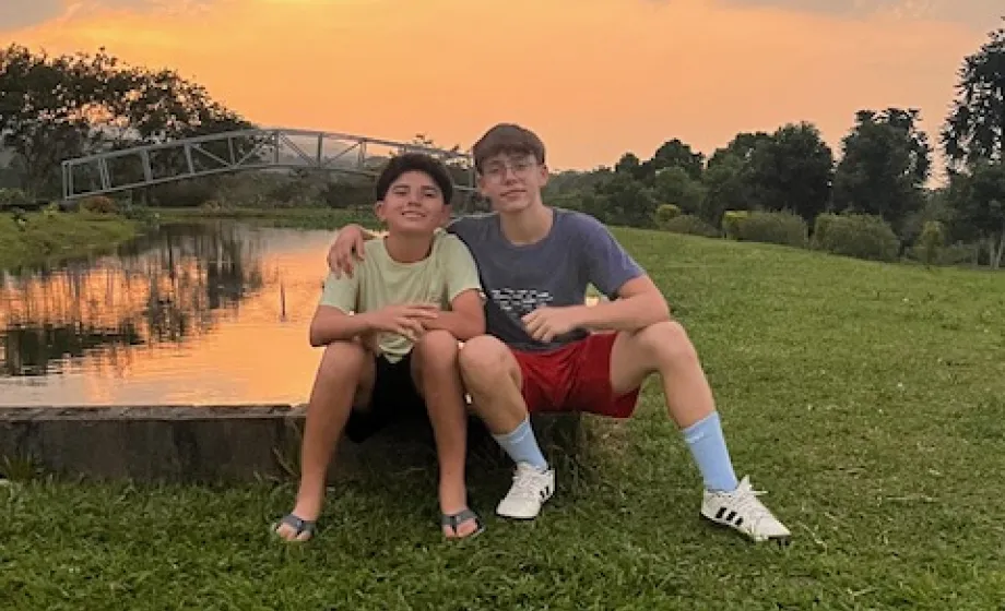 Schüler mit Gastbruder in Costa Rica auf Wiese bei Sonnenuntergang