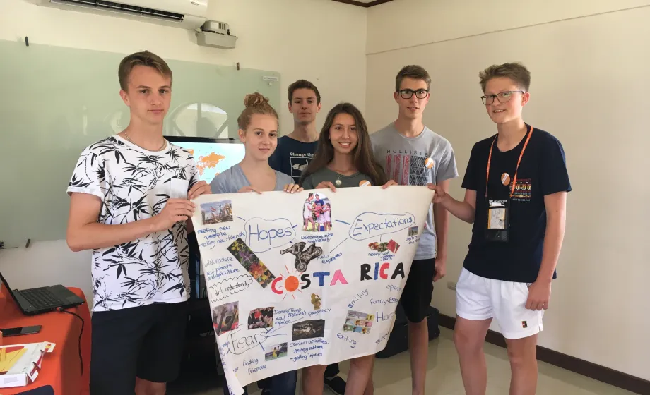 Schüler in Klassenzimmer mit Plakat lachend