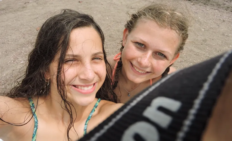Selfie Teenager am Strand lachend mit Sand im Gesicht