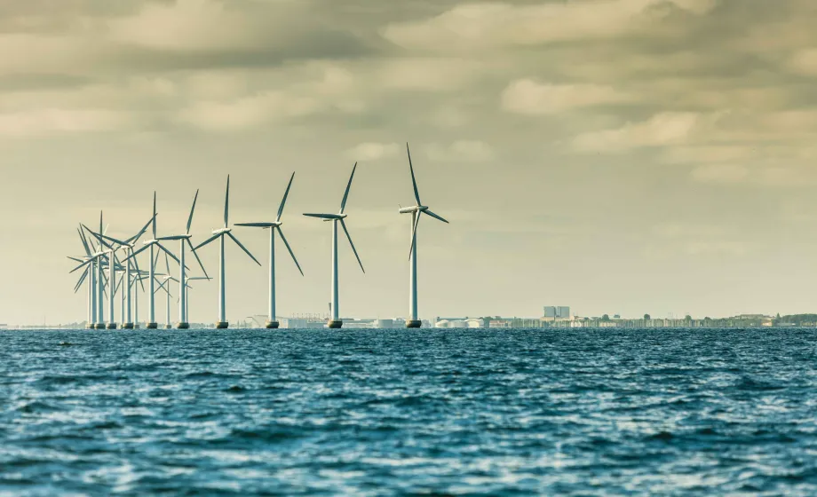 Windmühlen mit Meer im Vordergrund Stadt im Hintergrund